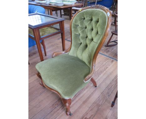 A mid Victorian walnut lady's chair, the button back and overstuffed seat on cabriole legs and castors 
