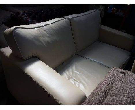 A cream leather two seater sofa