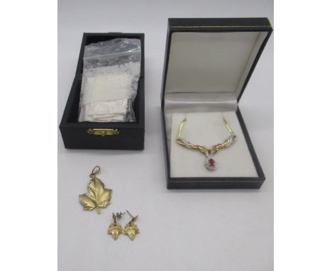 10ct yellow gold pendant and earring set in the form of a leaf and a 9ct gold necklace inset with diamonds twisted round a ce