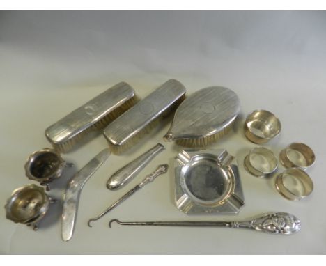 Two silver handled button hooks together with a pair of silver salts, silver napkin rings, an ashtray,a silver model of a boo