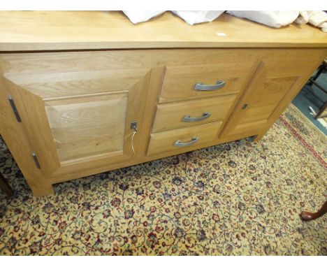 A modern light oak sideboard with three central drawers flanked by fielded cupboard doors, 171cm wide, 56cm deep, 85cm high