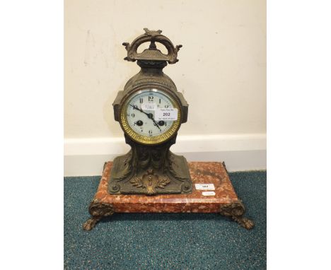 The French cast metal mantel clock on pink veined marble base