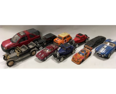 A group of large model vehicles in various scales and materials to include Porsche, Volkswagen, Mercedes, Triumph and Mini, m