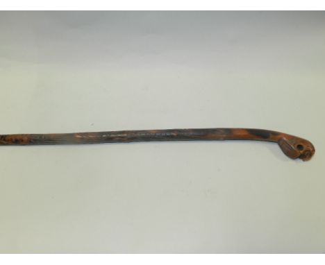 A South East Asian carved cane walking stick the pommel carved as a mythical beast