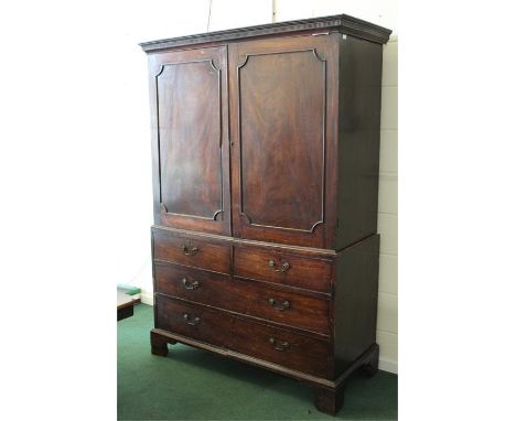 Victorian mahogany linen press, the gadrooned pediment above two panelled cupboard doors opening to reveal two sliding trays,