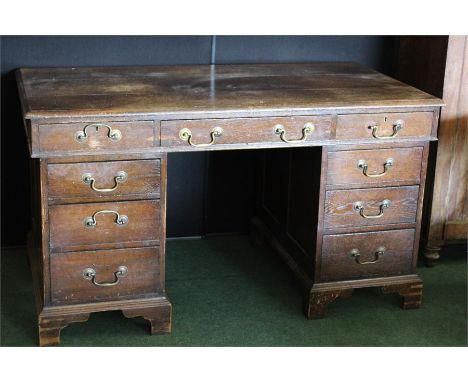 Edwardian oak twin pedestal desk, with three frieze drawers above three drawers to each pedestal, on bracket feet, 136cm wide