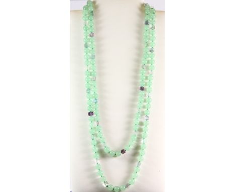 A very long necklace of pale green jade and fluorite beads, L 152cm