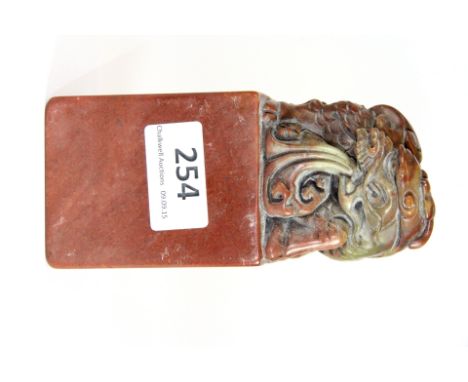 A large Chinese carved red soapstone seal mounted with a Qilin, 6cm x 6cm x 14cm