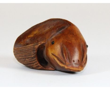 A signed fruitwood netsuke of a catfish with black onyx eyes