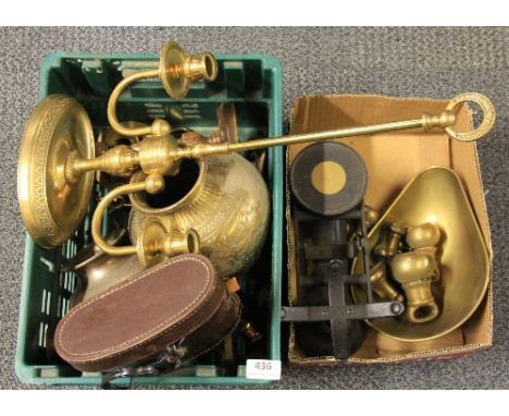 A brass scale with weights and other metal items