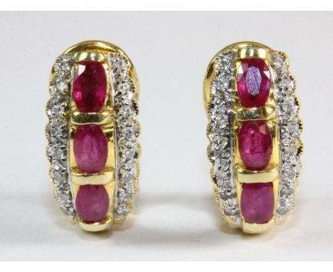 A pair of heavy yellow metal (tested 18ct gold) ruby and diamond earrings with pierced and clip over fitting