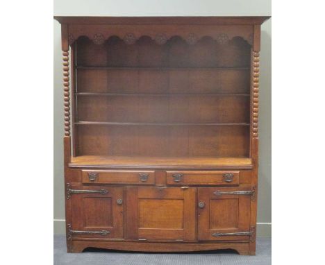 An early 20th century open topped oak dresser with bobbin turned supports above a bottom section comprising of drawers and st