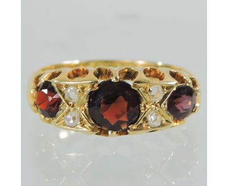 An 18 carat gold, garnet and diamond three stone ring, boxed 