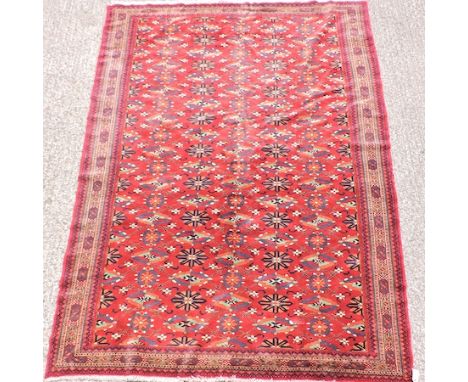 A Persian woollen carpet, with all over design, on a red ground, 195 x 280cm