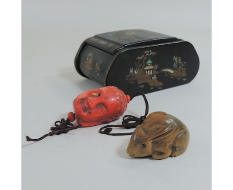 A Chinese carved coral pendant in the form of Buddha's head, 6cm, together with a boxwood netsuke in the form of a hare and a