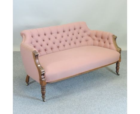 A late 19th century pink upholstered and carved walnut sofa, with a button back, on turned legs, 137cm