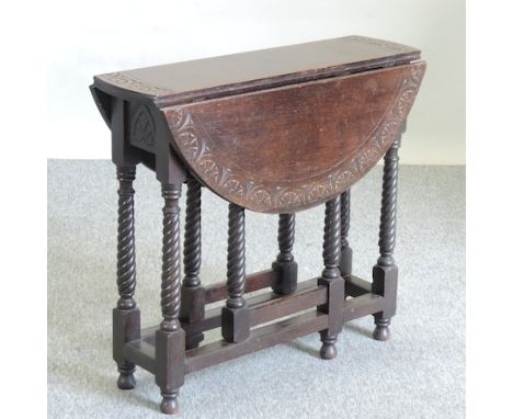 A 1920's carved oak gate leg side table, 76cm, together with a pot cupboard, stamped 'Heals & Son, London', to the door