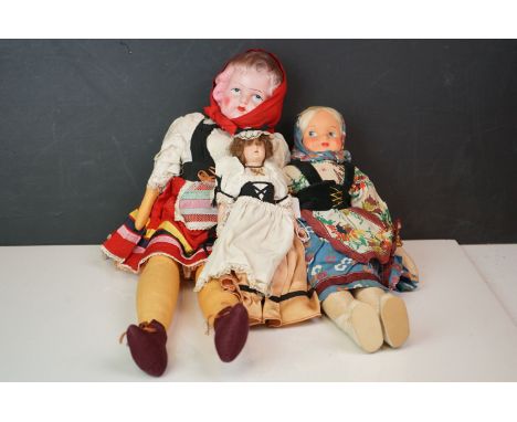 A collection of three vintage dolls in traditional dress. 