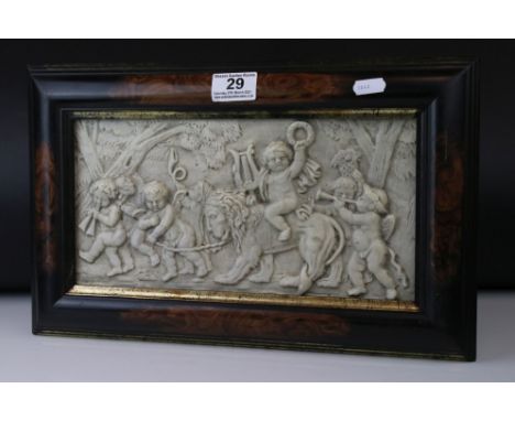 A composite stone framed panel decorated with cherubs playing with a lion one riding on the lions back. 