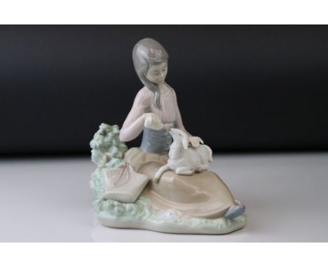 A Lladro figure of a Young girl bottle feeding a lamb. 