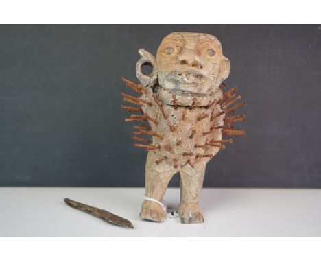 A vintage voodoo doll with spears and nails. 