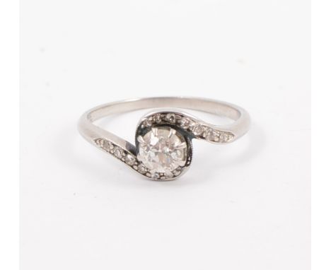 A diamond solitaire ring, the old brilliant cut stone claw set in a white metal crossover design mount, 1.4mm wide shank with