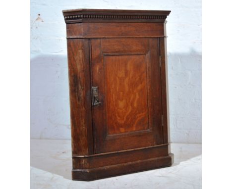 Small oak hanging corner cupboard, double door enclosing a single shelf, height 74cm.