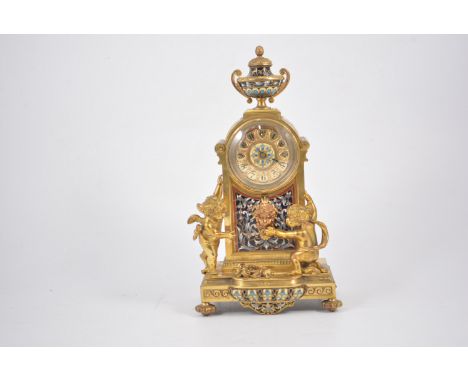 French ormolu and Champleve cased mantel clock, urn finial, the base with Cherub appliques.