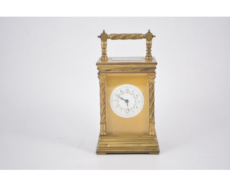 A French style carriage clock striking the hour and half hour on a gong, the circular 6cm white enamel dial having an arabic 