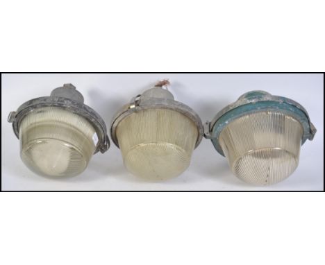 A pair of vintage 20th century Industrial GEC UFO type bulkhead lights with prism glass shades and metal bracket tops togethe