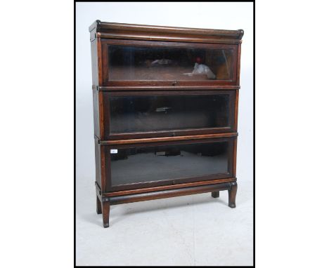 A 1920's Edwardian Globe Wernicke oak three tier sectional lawyers bookcase with glazed  up and over doors raised on stub leg