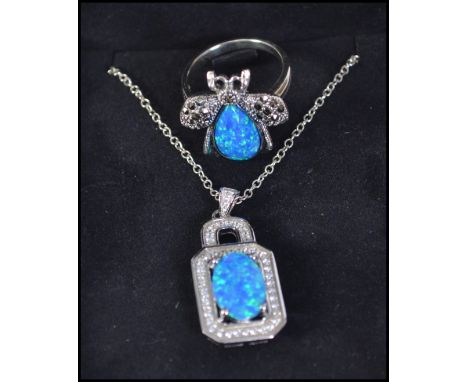 A silver and blue opal and cz adorned ladies dress ring together with a matching pendant necklace. Complete in the presentati