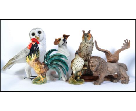 A good collection of animal and bird figures to include a to scale resin Jack Russell, Snowy Owl, carved lion, a ceramic cock