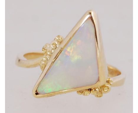 A boxed contemporary 18ct gold and opal ring set with a large triangular cut opal with naturalistic shoulder embellishment. H