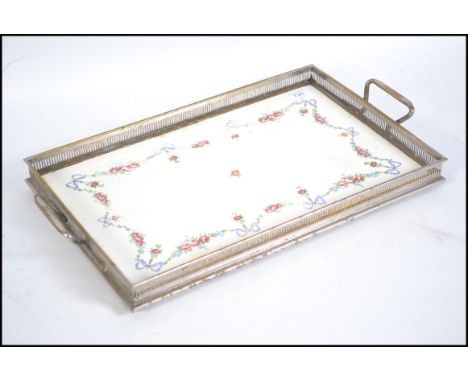 An early 20th century silver plate and ceramic lined salver tray with lattie gallery and twin handles. Unmarked, likely of co