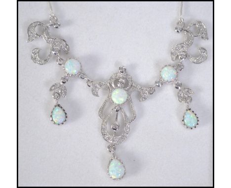 A very pretty silver cz and opal adorned necklace in the Art Nouveau style set to a snake linked chain in green leather prese