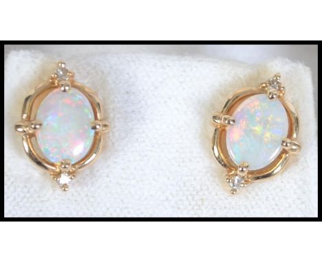 A  pair of 14ct gold opal and diamond earrings. Marked 585. Total weight 2.8g.