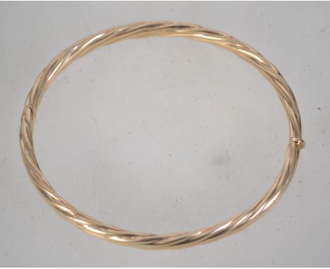 A hallmarked 9ct gold bangle bracelet with hidden clip clasp. Hallmarked Sheffield. Weight 10.4g