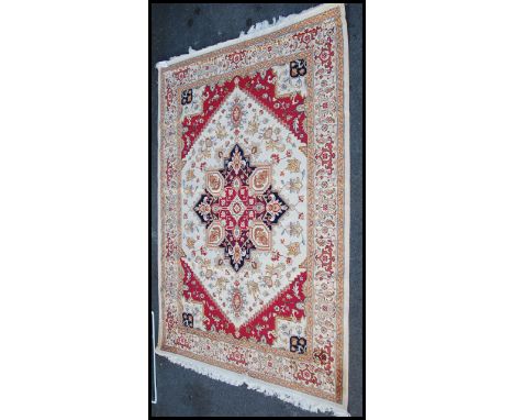 A large North Western Iranian / Persian Heriz carpet - rug having beige ground with geometric decoration and borders. Measure