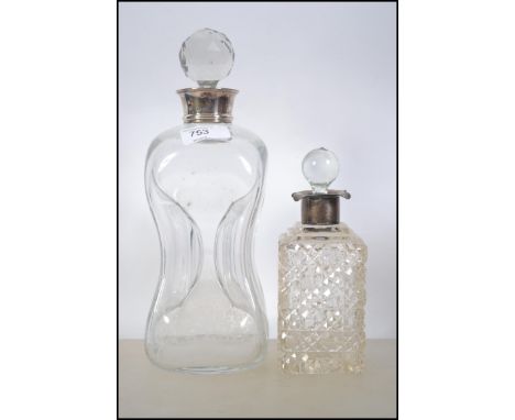 Two silver collared glass decanters the first being a Holmegaard Kluk Kluk Pinched Decanter with a later faceted stopper. 27c