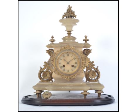 A Victorian alabaster mantel clock with gilded finials inset brass movement striking on a bell ( af ) Measures 45cms high.