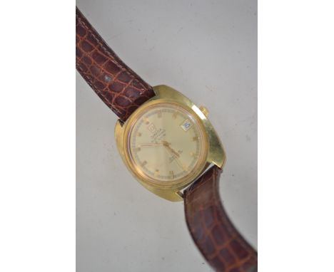 A vintage gentlemans Omega F300 day-date chronometer watch of brass colour mounted on a brown leather strap