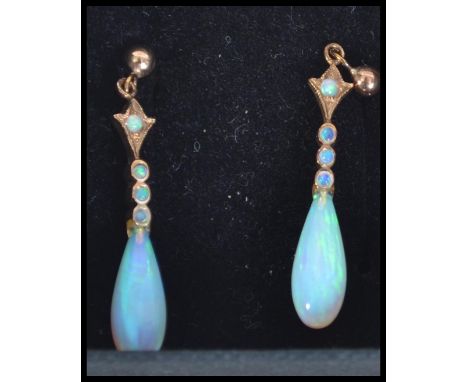 A pair of 9ct gold and opal drop earrings. Unmarked test 9ct gold. Measure drop 1.25 inches. Weight 1.6g.