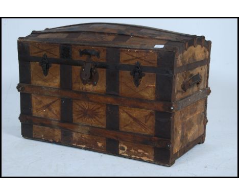 A Victorian wooden and metal bound dome top steamer trunk chest having hinged lid with all over line stencil detail. Measures