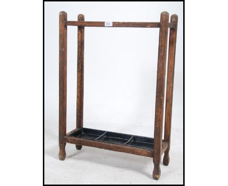 An Edwardian / 20th century two divisional oak stick / umbrella stand of simple form retaining both drip tray's.