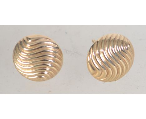 A pair of 9ct gold button stud earrings with wave decoration. Weight 1g.