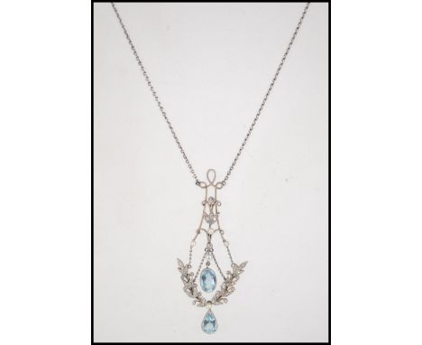 An Edwardian 18ct gold Art Nouveau pendant necklace strung with stylized rose cut diamond set wreaths set with seed pearls an