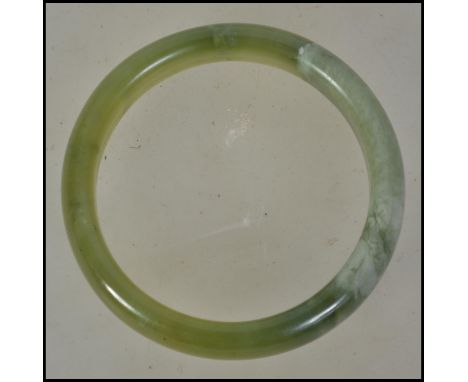 A 20th century Chinese spinach jade bangle of rounded form. Please see images.