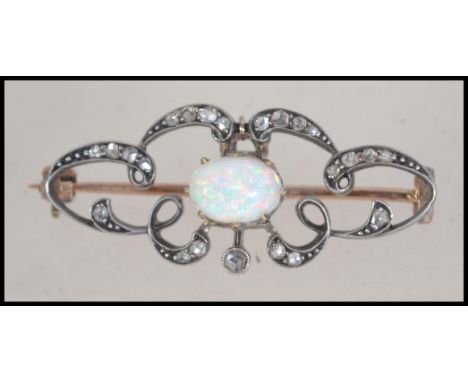 A Victorian Art Nouveau 9ct gold and silver diamond and opal brooch having an articulating pendant. Measures 4cms. Total weig