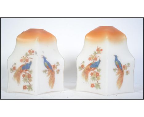 A pair of 1930's Art Deco glass light shades being decorated with birds of paradise and fauna standing 18cm tall.